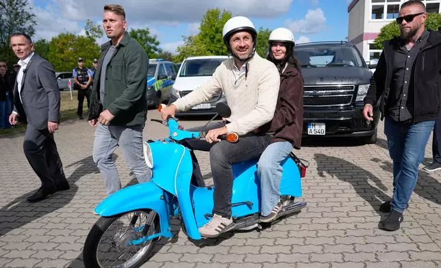 Ulrich Siegmund, top candidate for the "Alternative for Germany" (AfD) party and his wife Julia leaving a polling station on a small Schwalbe motorcycle after voting during the Saxony-Anhalt state elections in Tangermuende, eastern Germany, Sunday, Sept. 6, 2026. (AP Photo/Matthias Schrader)