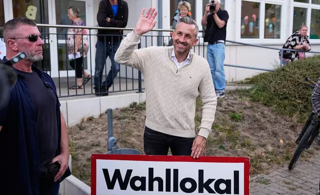Ulrich Siegmund, top candidate for the "Alternative for Germany" (AfD) party waves to supporters at a polling station after voting during the Saxony-Anhalt state elections in Tangermuende, eastern Germany, Sunday, Sept. 6, 2026. (AP Photo/Matthias Schrader)