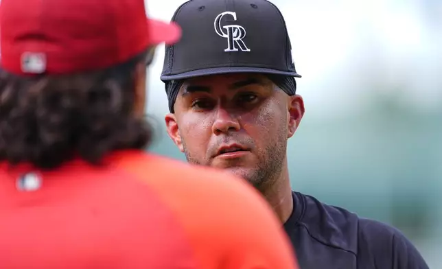 Colorado Rockies infielder Vimael Machin, right, talks with St. Louis Cardinals bullpen catcher Kleininger Teran, left, before a baseball game Saturday, Sept. 5, 2026, in Denver. (AP Photo/David Zalubowski)