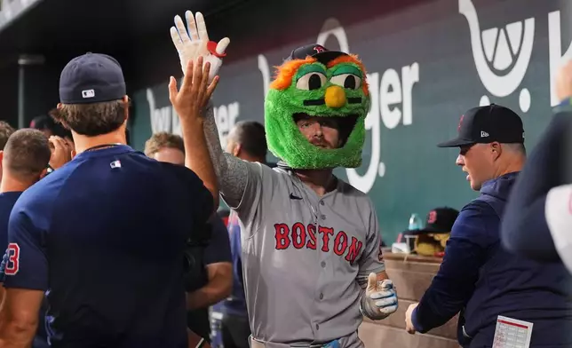 Boston Red Sox's Trevor Story, center, celebrates with the team after hitting a three-run home run in the eighth inning of a baseball game against the Texas Rangers Thursday, Sept. 17, 2026, in Arlington, Texas (AP Photo/Tony Gutierrez)