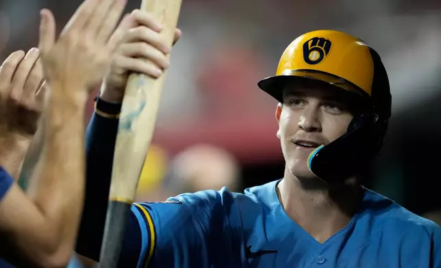 Milwaukee Brewers Cooper Pratt celebrates in the dugout after scoring on a wild pitch by Cincinnati Reds pitcher Sam Moll the fifth inning of a baseball game, Friday, Sept. 4, 2026, in Cincinnati. (AP Photo/Carolyn Kaster)
