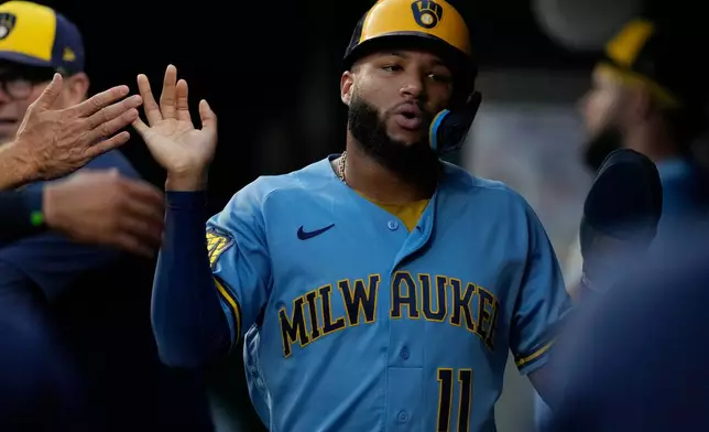 Milwaukee Brewers' Jackson Chourio celebrates in the dugout after scoring on a double hit by Brice Turang in the third of a baseball game against the Cincinnati Reds, Friday, Sept. 4, 2026, in Cincinnati. (AP Photo/Carolyn Kaster)