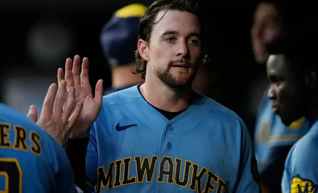 Milwaukee Brewers' Brice Turang celebrates in the dugout after hitting a double to score Jackson Chourio and William Contreras in the third of a baseball game against the Cincinnati Reds, Friday, Sept. 4, 2026, in Cincinnati. (AP Photo/Carolyn Kaster)