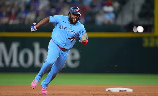 Toronto Blue Jays first baseman Vladimir Guerrero Jr. runs from first to third base on a hit by teammate Alejandro Kirk against the Texas Rangers during the eighth inning of a baseball game Saturday, Sept. 19, 2026, in Arlington, Texas. (AP Photo/Julio Cortez)