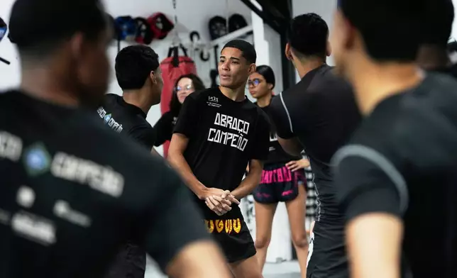 Youth attend a martial arts class at Abraco Campeao, or Embrace Champions, an academy that offers free boxing, jiu-jitsu, Muay Thai and capoeira classes, as well as educational talks on topics ranging from environmental issues to relationships, in the Complexo de Alemao favela in Rio de Janeiro, Wednesday, Sept. 16, 2026. (AP Photo/Silvia Izquierdo)