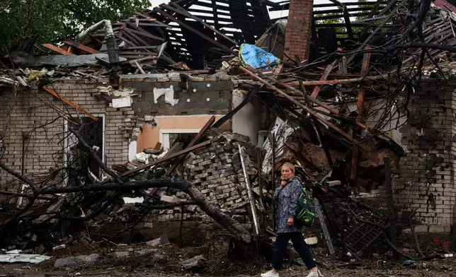 A woman walks in front of a house destroyed in a Russian strike on a residential neighbourhood in Kyiv, Ukraine, Thursday, Sept. 24, 2026. (AP Photo/Evgeniy Maloletka)