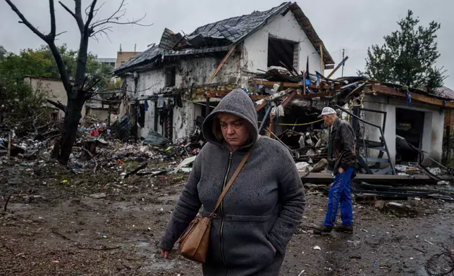A woman walks in front of a house that was heavily damaged in a Russian strike on a residential neighbourhood in Kyiv, Ukraine, Thursday, Sept. 24, 2026. (AP Photo/Evgeniy Maloletka)