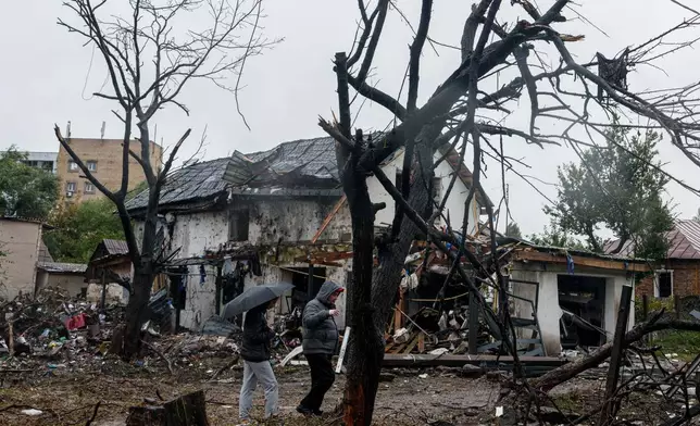 People walk in front of a house that was heavily damaged in a Russian strike on a residential neighbourhood in Kyiv, Ukraine, Thursday, Sept. 24, 2026. (AP Photo/Evgeniy Maloletka)