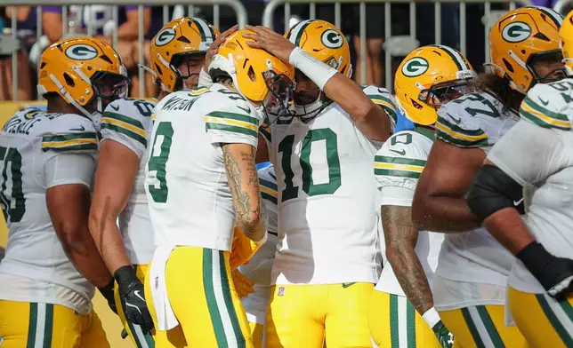 Green Bay Packers' Christian Watson (9) and Jordan Love (10) celebrate Watson's touchdown catch during the first half of an NFL football game against the Minnesota Vikings, Sunday, Sept. 13, 2026, in Minneapolis, Minn. (AP Photo/Bailey Hillesheim)