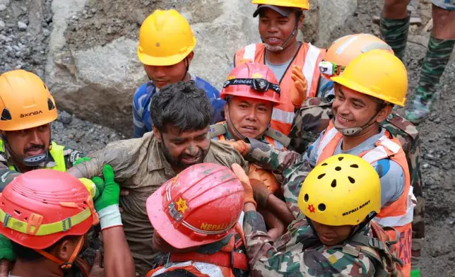 In this photo provided by the Nepal Army, soldiers rescue a worker alive from a tunnel during an ongoing operation at the Trishuli-3A hydropower project in Nepal's Rasuwa district, Friday, Sept. 4, 2026. (Nepal Army via AP)