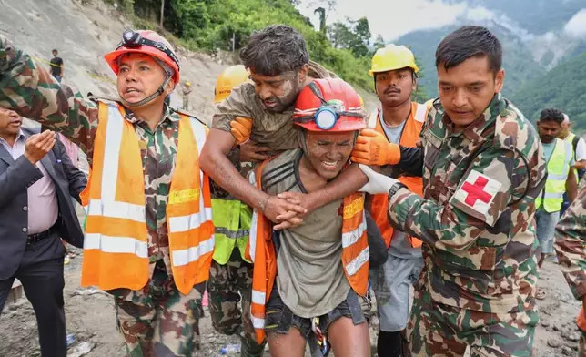 In this photo provided by the Nepal Army, soldiers rescue a worker alive from a tunnel during an ongoing operation at the Trishuli-3A hydropower project in Nepal's Rasuwa district, Friday, Sept. 4, 2026. (Nepal Army via AP)