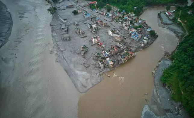 A drone view shows houses damaged by flash floods surrounded by sludge, mud and debris along the swollen Trishuli River in Devighat, Nepal, Thursday, Sept. 3, 2026. (AP Photo/Rajesh Kumar Singh)