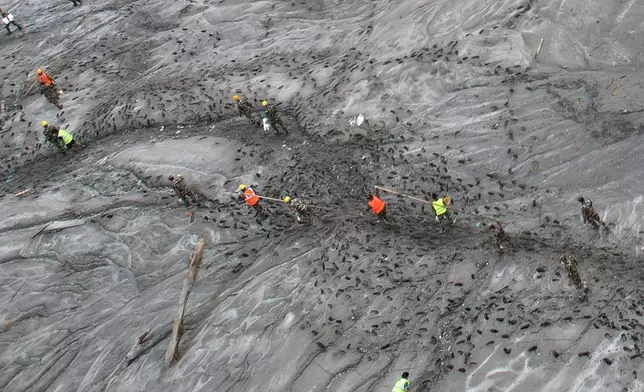 A drone view shows rescue workers inspecting damaged structures amid sludge, debris and landslides in the aftermath of flash flooding along the Trishuli River in the Devighat area of Nepal's Nuwakot district, Saturday, Aug. 29, 2026. (AP Photo/Rajesh Kumar Singh)