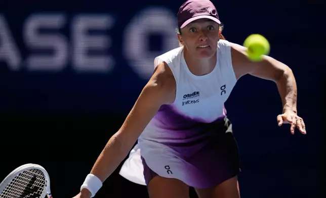 Iga Swiatek, of Poland, returns the ball to Qinwen Zheng, of China, during the fourth round of the U.S. Open tennis championships, Monday, Sept. 7, 2026, in New York. (AP Photo/Seth Wenig)