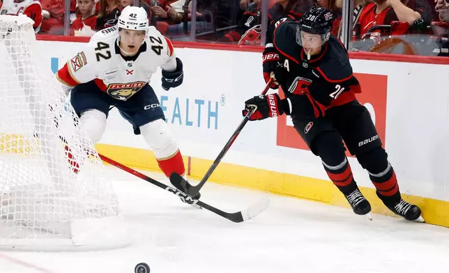 Carolina Hurricanes' Sebastian Aho (20) chases the puck with Florida Panthers' Gustav Forsling (42) nearby during the second period of an NHL hockey game in Raleigh, N.C., Tuesday, Sept. 29, 2026. (AP Photo/Karl DeBlaker)