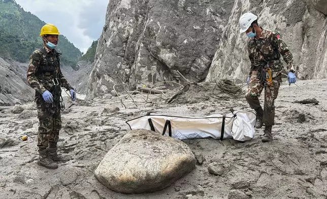 Nepal Army soldiers carry a body of a worker recovered from the site of a hydropower project in Upper Trishuli, Nepal, Tuesday, Sept. 1, 2026. (AP Photo/Kaslai Dine)