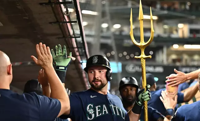 Seattle Mariners' Cal Raleigh, center, is greeted by teammates after hitting a three-run home run during the fourth inning of a baseball game against the Los Angeles Angels, Monday, Sept. 14, 2026, in Anaheim, Calif. (AP Photo/William Liang)