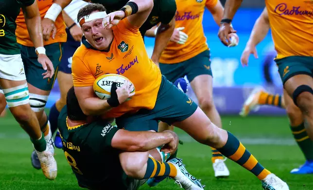 Australia's Angus Bell, center, is tackled by South Africa's Marco van Staden during their rugby union test match in Perth, Australia, on Sunday, Sept. 27, 2026. (AP Photo/Gary Day)