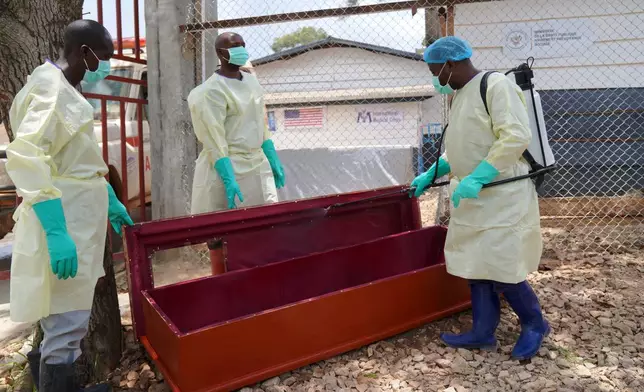 Health workers who are members of the safe and dignified burial team disinfect a coffin to bury Abineno Justine, a 38 year old woman who died of the Ebola virus, in Bunia, Congo, Friday, Sept. 4, 2026. (AP Photo/Dieudonne Dirole)