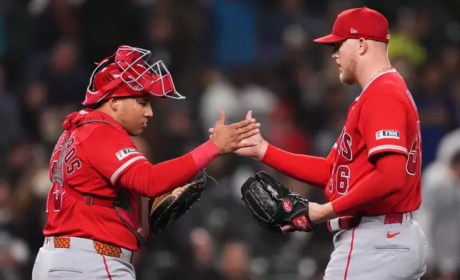 Los Angeles Angels catcher Moisés Ballesteros greets relief pitcher Ryan Watson as they celebrate a win over the Seattle Mariners in a baseball game, Thursday, Sept. 24, 2026, in Seattle. (AP Photo/Lindsey Wasson)