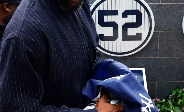 Hall of Famer CC Sabathia unveils his No. 52 during his Monument Park induction ceremony before a baseball game between the New York Yankees and Baltimore Orioles, Friday, Sept. 25, 2026, in New York. (AP Photo/Noah K. Murray)