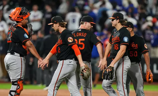 Baltimore Orioles' Gunnar Henderson (2), Pete Alonso (25) and Coby Mayo (16) celebrate with teammates after a baseball game against the New York Mets Monday, Sept. 14, 2026, in New York. (AP Photo/Frank Franklin II)