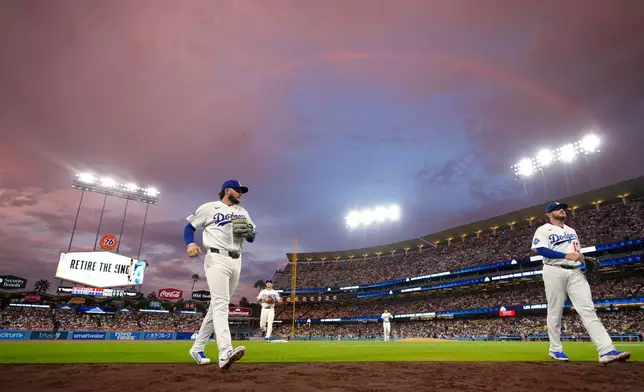 Los Angeles Dodgers' Alex Freeland, left, and Max Muncy walk in as a rainbow is seen above them after the top of the fifth inning of a baseball game against the Cincinnati Reds, Monday, Sept. 7, 2026, in Los Angeles. (AP Photo/Mark J. Terrill)