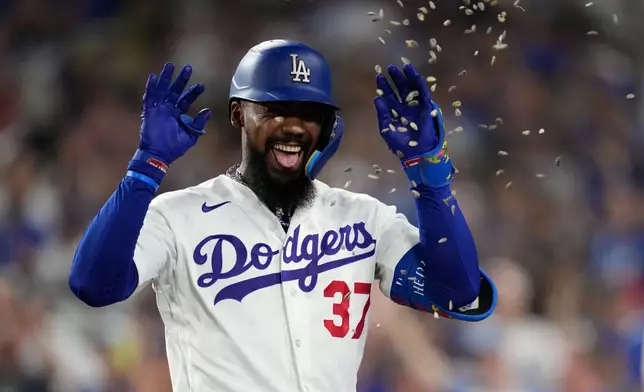 Los Angeles Dodgers' Teoscar Hernández has seeds thrown at him after hitting a three-run home run during the sixth inning of a baseball game against the Cincinnati Reds, Monday, Sept. 7, 2026, in Los Angeles. (AP Photo/Mark J. Terrill)
