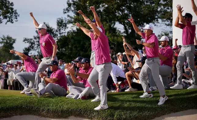 Members of the USA team celebrate Jackson Koivun's win on the 18th green against the International team during a Presidents Cup golf tournament final round singles match at Medinah Country Club, Sunday, Sept. 27, 2026, in Medinah, Ill. (AP Photo/Matt Slocum)