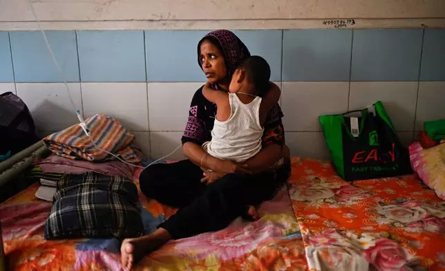 A woman takes care of her child while getting treatment for measles during the outbreak, in a hospital in Dhaka, Bangladesh, Tuesday, Sept. 8, 2026. (AP Photo/Mahmud Hossain Opu)