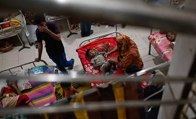 Patients receive treatment during a measles outbreak as family members sit beside them in an overcrowded hospital in Dhaka, Bangladesh, Tuesday, Sept. 8, 2026. (AP Photo/Mahmud Hossain Opu)