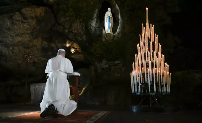 In this handout photo provided by Vatican Media Pope Leo XIV prays at the Grotto of the Apparitions of Massabielle, in Lourdes, France, Saturday, Sept. 26, 2026. (Vatican Media via AP)
