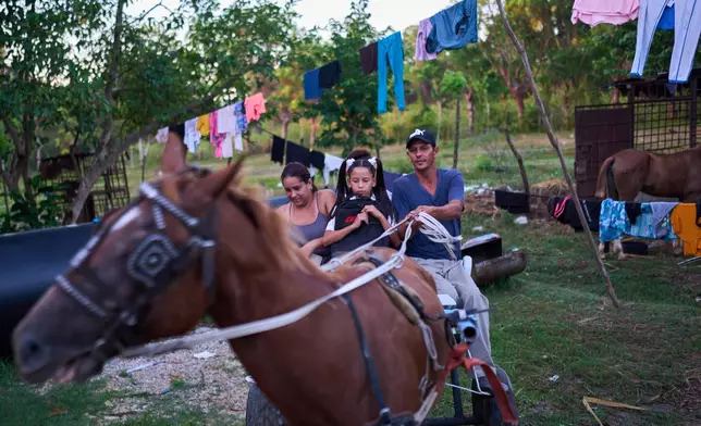 The Barroso family travels by horse-drawn carriage as they head to school for their two daughters' first day back to classes in Minas, Cuba's Havana province, Tuesday, Sept. 1, 2026. (AP Photo/Ramon Espinosa)