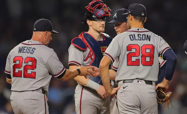 Atlanta Braves' JR Ritchie, middle, is taken out by manger Walt Weiss, left, during the fifth inning of a baseball game against the Chicago Cubs, Wednesday, Sept. 16, 2026, in Chicago. (AP Photo/Melissa Tamez)