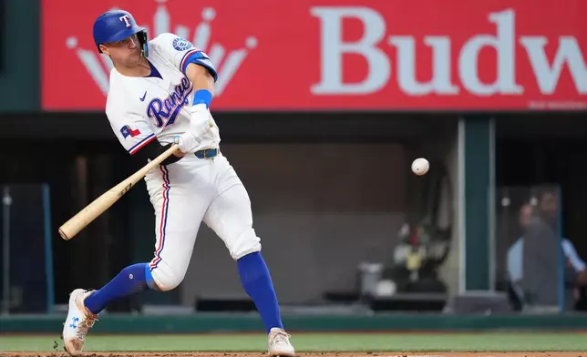 Texas Rangers' Josh Jung swings at a pitch before hitting a two-run home run against the New York Mets during the first inning of a baseball game Thursday, Sept. 24, 2026, in Arlington, Texas. (AP Photo/Julio Cortez)