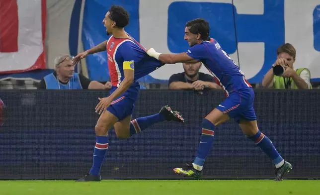 PSG's Marquinhos, left, celebrates with Ferran Torres after scoring his side's 2nd goal during the French League One soccer match between Marseille and Paris Saint-Germain in Marseille, France, Sunday, Sept. 20, 2026. (AP Photo/Philippe Magoni)