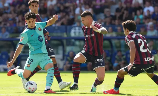 Barcelona's Xavi Espart, left, scores his side's first goal during the Spanish La Liga soccer match between Levante and Barcelona in Valencia, Sunday, Sept. 13, 2026. (AP Photo/Alberto Saiz)