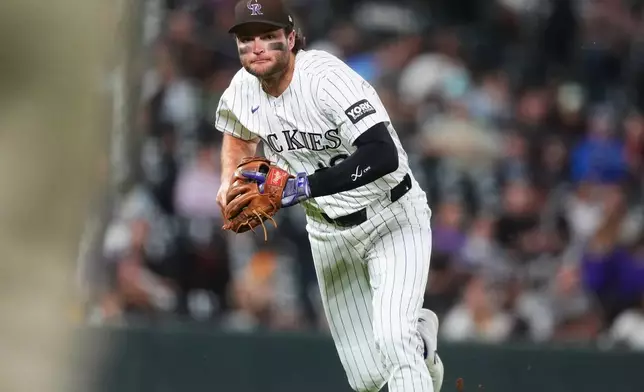 Colorado Rockies third baseman Kyle Karros throws to first base to put out San Diego Padres' Jake Cronenworth in the fifth inning of a baseball game Wednesday, Sept. 16, 2026, in Denver. (AP Photo/David Zalubowski)