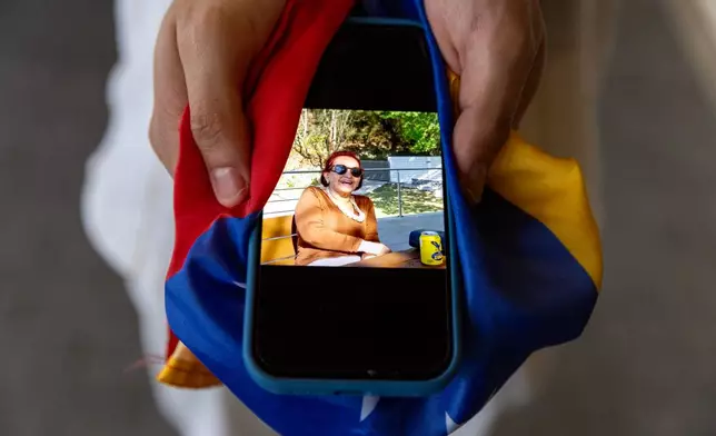 Alejandro Marquina shows a photo of his aunt Yolanda Suárez on his phone after the earthquakes killed her and four other members of his family in his home state of La Guaira, on Saturday, Aug. 29, 2026, in Doral, Fla. (AP Photo/David Santiago)