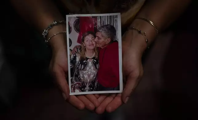 Kelly Granado, whose parents, Marina and Jesús, died in Venezuela's June 24 earthquakes, holds a photo of them at her restaurant in downtown Los Angeles, Tuesday, Aug. 25, 2026. (AP Photo/Jae C. Hong)