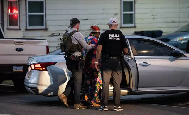Lakiya Malone, center, charged with fraud involving federal homelessness aid programs, is arrested by federal agents in Los Angeles, Wednesday, Sept. 16, 2026. (AP Photo/Jae C. Hong)