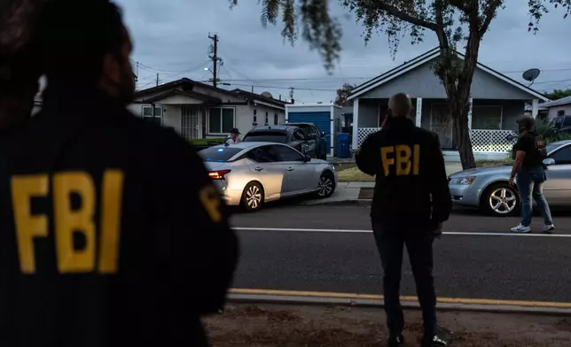 FBI agents stand outside the home of Lakiya Malone, who is charged with fraud involving federal homelessness aid programs, in Los Angeles, Wednesday, Sept. 16, 2026. (AP Photo/Jae C. Hong)