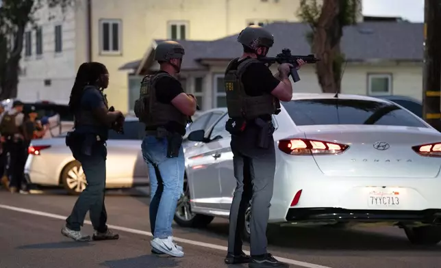 FBI agents take positions outside the home of Lakiya Malone, who is charged with fraud involving federal homelessness aid programs, in Los Angeles, Wednesday, Sept. 16, 2026. (AP Photo/Jae C. Hong)