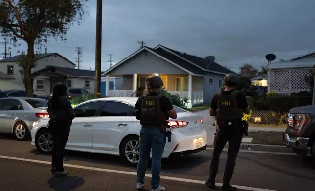 FBI agents take positions outside the home of Lakiya Malone, who is charged with fraud involving federal homelessness aid programs, in Los Angeles, Wednesday, Sept. 16, 2026. (AP Photo/Jae C. Hong)