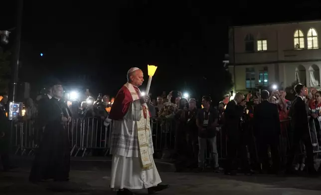 Pope Leo XIV holds a candle during a prayer of Holy Rosary and torchlight procession at the Sanctuary of Our Lady of Lourdes, France, Sunday, Sept. 27, 2026. (AP Photo/Thibault Camus)