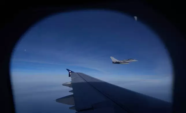 A French Air Force Dassault Rafale C fighter jet is seen through a window of the aircraft carrying Pope Leo XIV from Lourdes to Metz on the last day of his four-day visit to France, Monday, Sept. 28, 2026. (AP Photo/Gregorio Borgia, Pool)