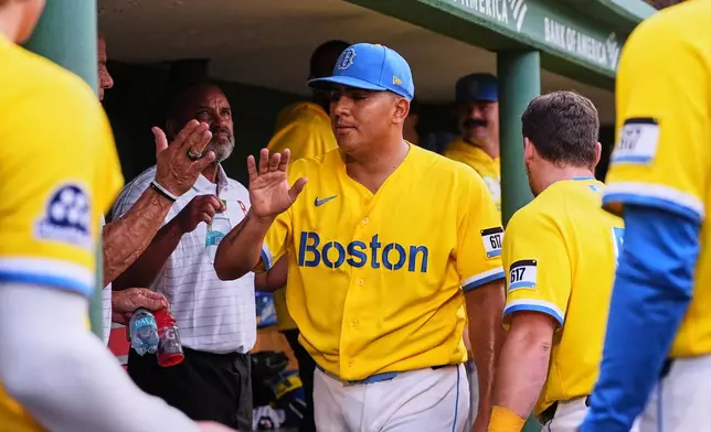 Boston Red Sox starting pitcher Ranger Suarez is congratulated by teammates following the top of the seventh inning of a baseball game after his outing against the Kansas City Royals, Saturday, Sept. 12, 2026, in Boston. (AP Photo/Charles Krupa)
