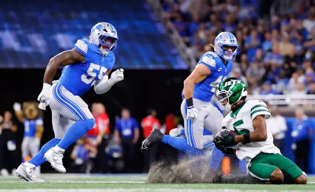 New York Jets' Garrett Wilson catches a pass in front of Detroit Lions' Derrick Barnes and Jack Campbell during the first half of an NFL football game in Detroit, Sunday, Sept. 27, 2026. (AP Photo/Ray Del Rio)