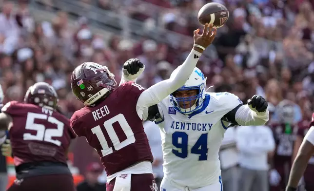 Texas A&M quarterback Marcel Reed (10) is pressured by Kentucky defensive lineman Tavion Gadson (94) during the second half of an NCAA college football game Saturday, Sept. 19, 2026, in College Station, Texas. (AP Photo/David J. Phillip)