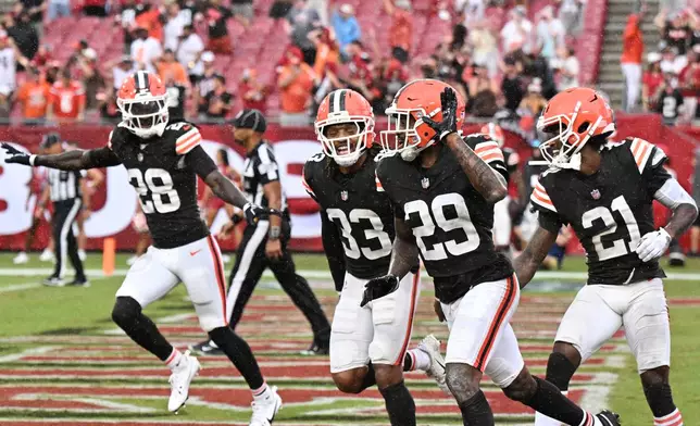 Cleveland Browns safety Emmanuel McNeil-Warren (28), safety Ronnie Hickman (33), cornerback Mekhi Blackmon (29) and cornerback Denzel Ward (21) celebrate after the Tampa Bay Buccaneers were not able to complete a fourth down pass during the second half of an NFL football game in Tampa, Fla., Sunday, Sept. 20, 2026. (AP Photo/Jason Behnken)